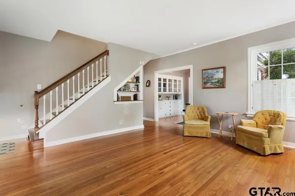 a living room with furniture and a table with wooden floor