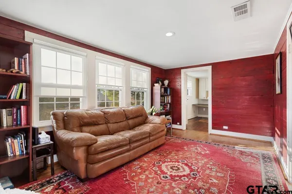 a living room with furniture and a book shelf