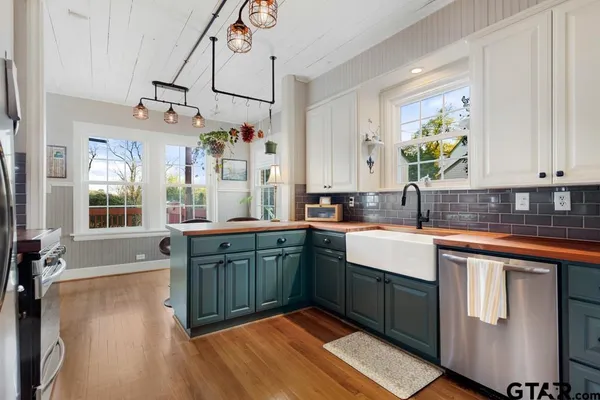 a kitchen with stainless steel appliances granite countertop a sink dishwasher and cabinets with wooden floor