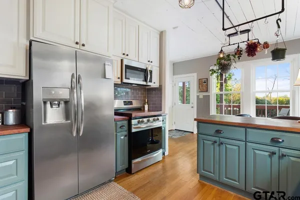 a kitchen with stainless steel appliances granite countertop a refrigerator a stove and a sink