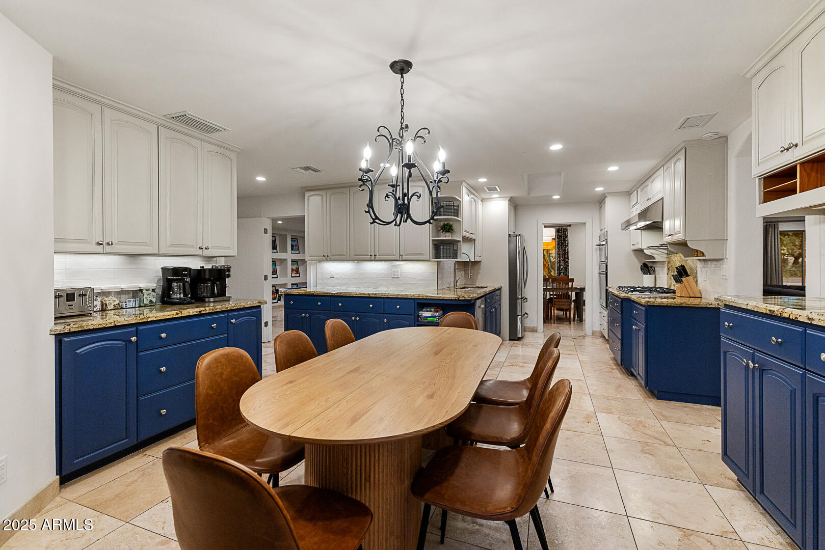 8433 East Cholla Street Scottsdale, AZ 85260 - Photo 11 of 29 a kitchen with stainless steel appliances kitchen island granite countertop a sink a stove a kitchen island with chairs and cabinets