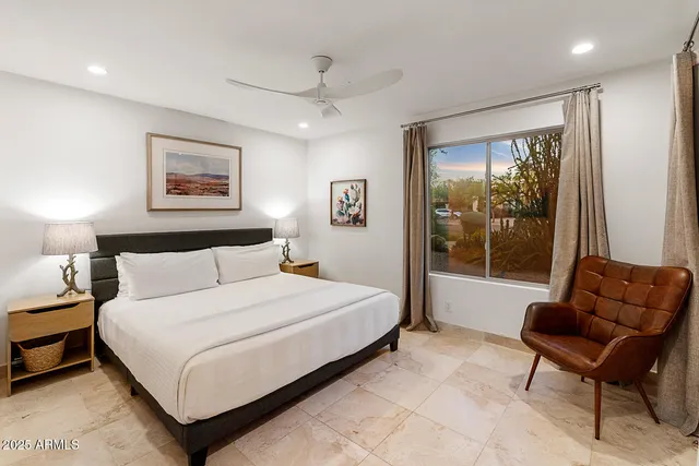 a bedroom with a large bed and a chandelier