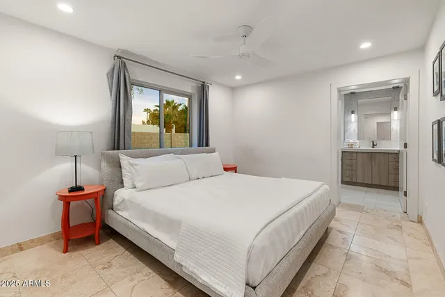 a bedroom with a bed and a large window