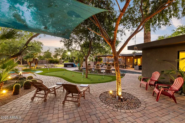 a view of a swimming pool with lawn chairs under an umbrella