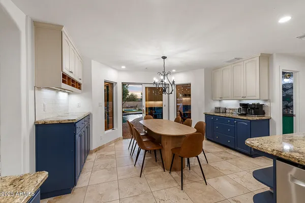 a kitchen with stainless steel appliances kitchen island granite countertop a sink a stove a kitchen island with chairs and cabinets