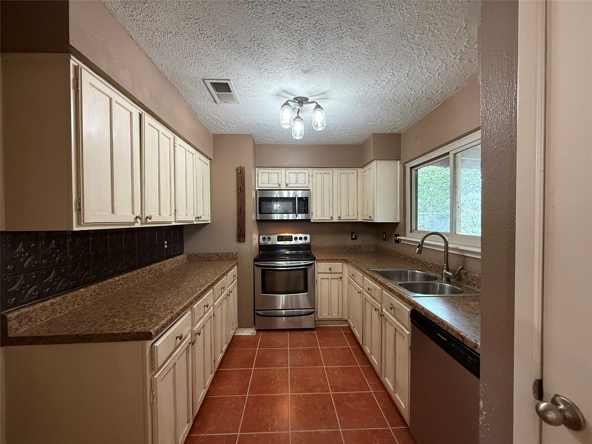 4722 Enchanted Rock Lane Spring, TX 77388 - Photo 5 of 22 a kitchen with stainless steel appliances granite countertop a sink stove and cabinets