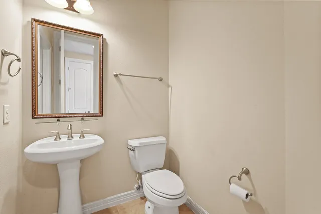 a bathroom with a sink a toilet and mirror