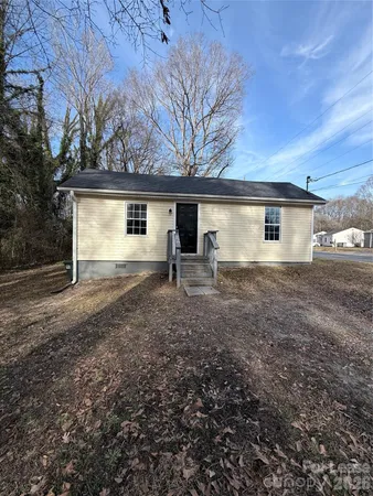 a view of a house with backyard and trees