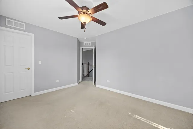 an empty room with closet and a chandelier fan