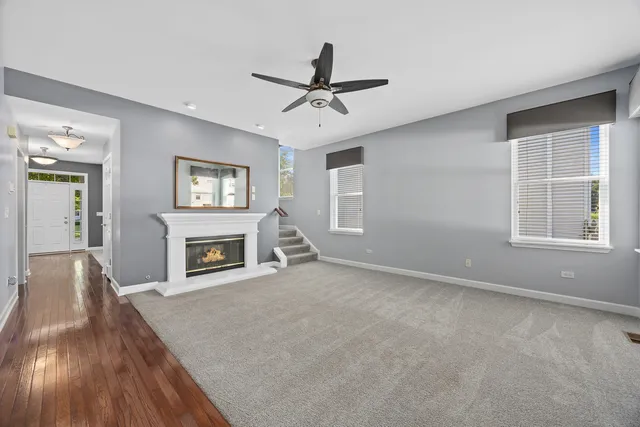 a view of livingroom with fireplace ceiling fan and windows