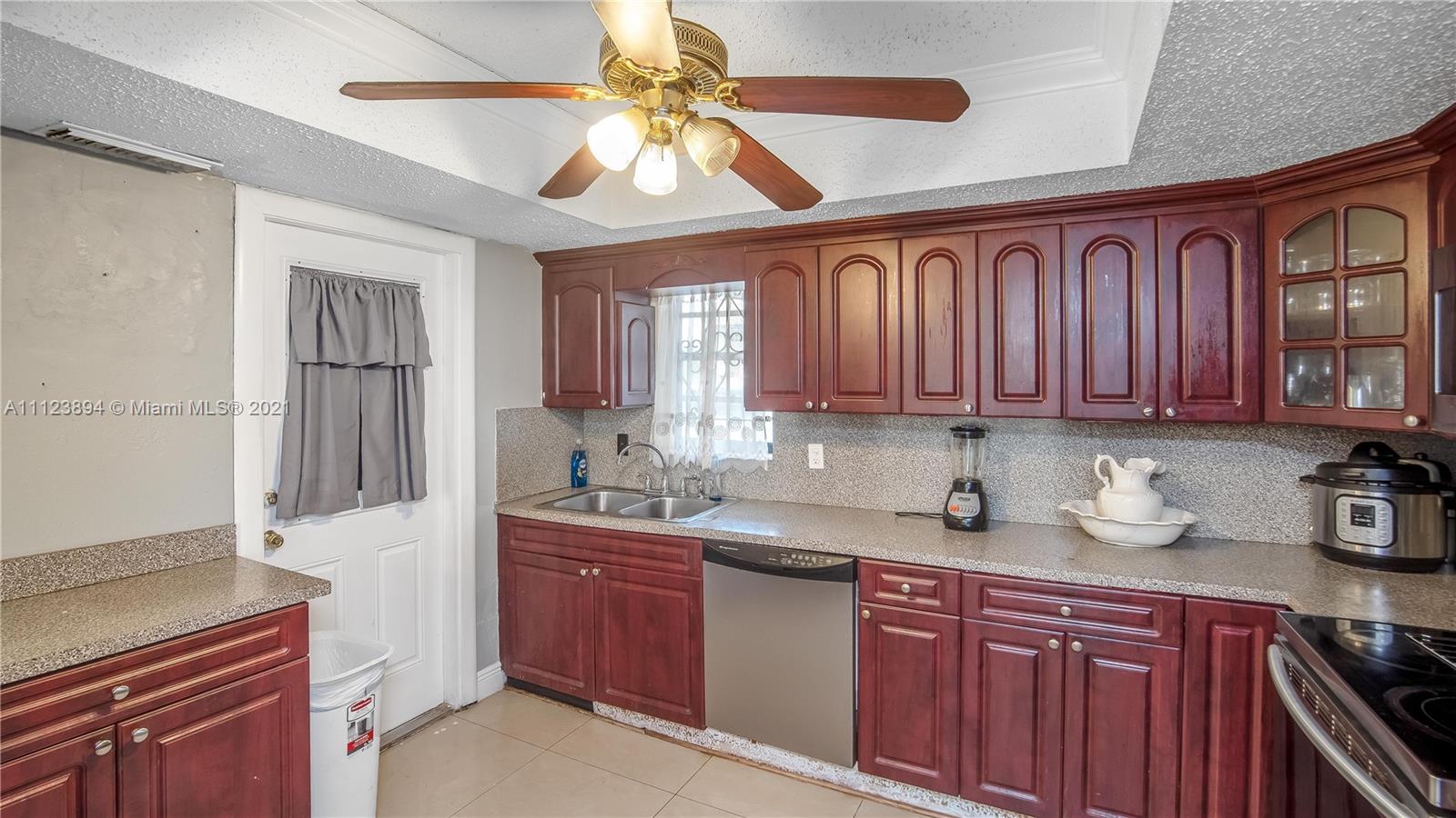 20020 Southwest 112th Avenue Miami, FL 33189 - Photo 11 of 39 a kitchen with stainless steel appliances granite countertop a sink stove and cabinets