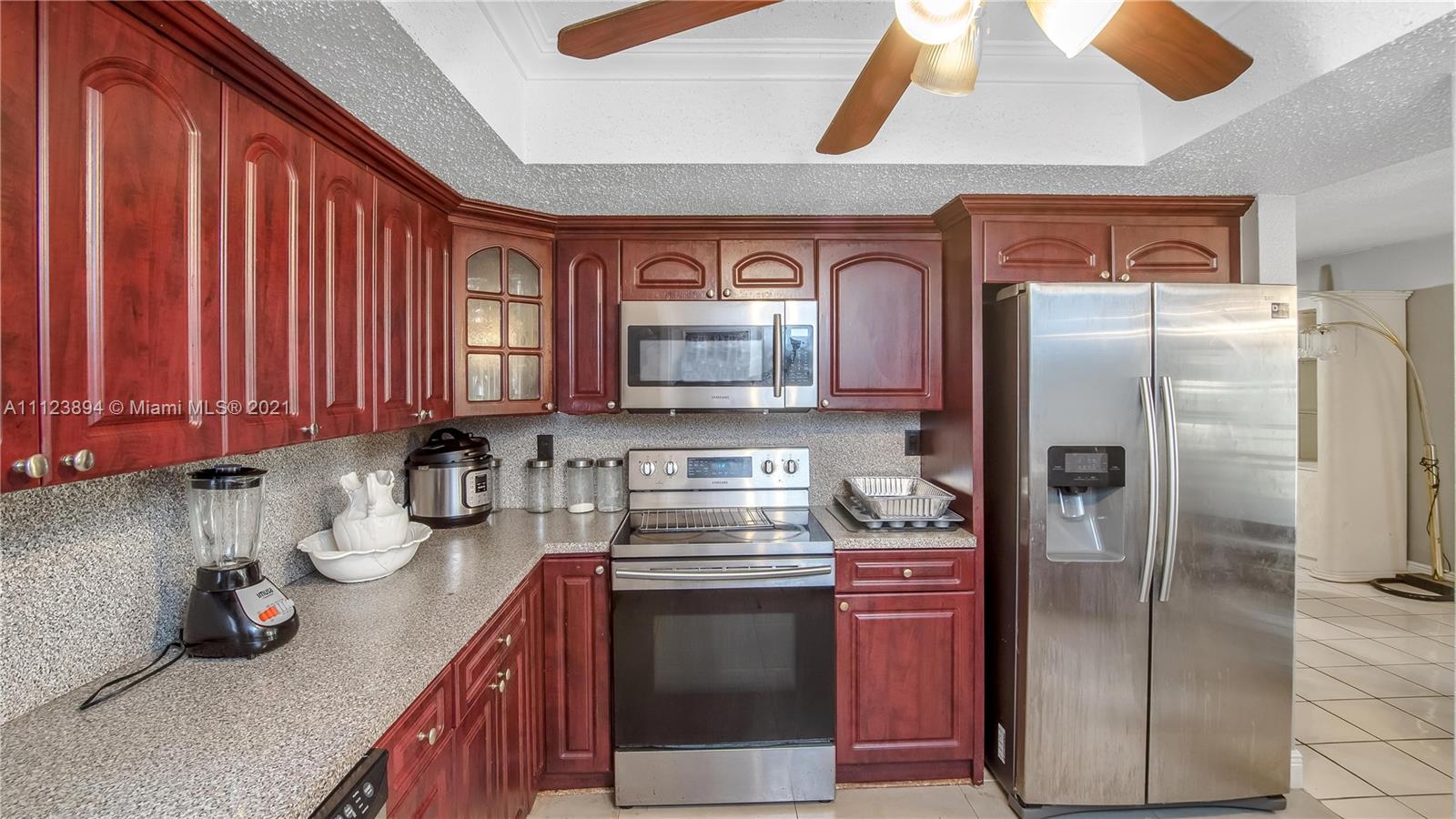 20020 Southwest 112th Avenue Miami, FL 33189 - Photo 12 of 39 a kitchen with stainless steel appliances granite countertop a refrigerator and a stove