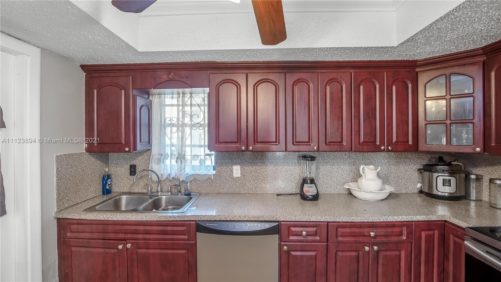 20020 Southwest 112th Avenue Miami, FL 33189 - Photo 14 of 39 a kitchen with stainless steel appliances granite countertop a sink a stove cabinets and wooden floor