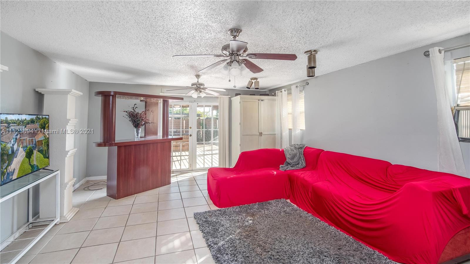 20020 Southwest 112th Avenue Miami, FL 33189 - Photo 17 of 39 a bedroom with a large bed and a chandelier