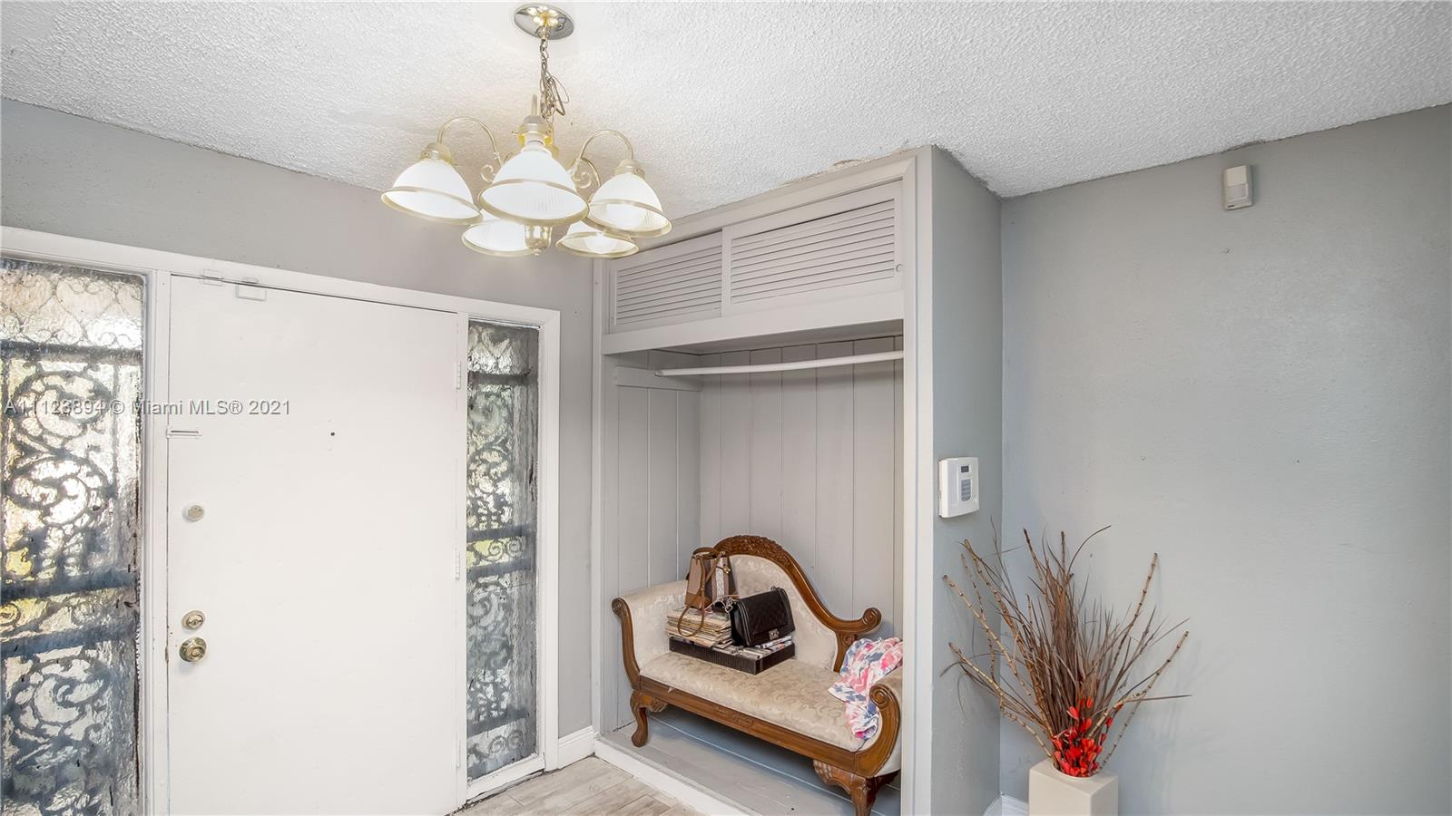20020 Southwest 112th Avenue Miami, FL 33189 - Photo 23 of 39 a bedroom with a bed and a chandelier