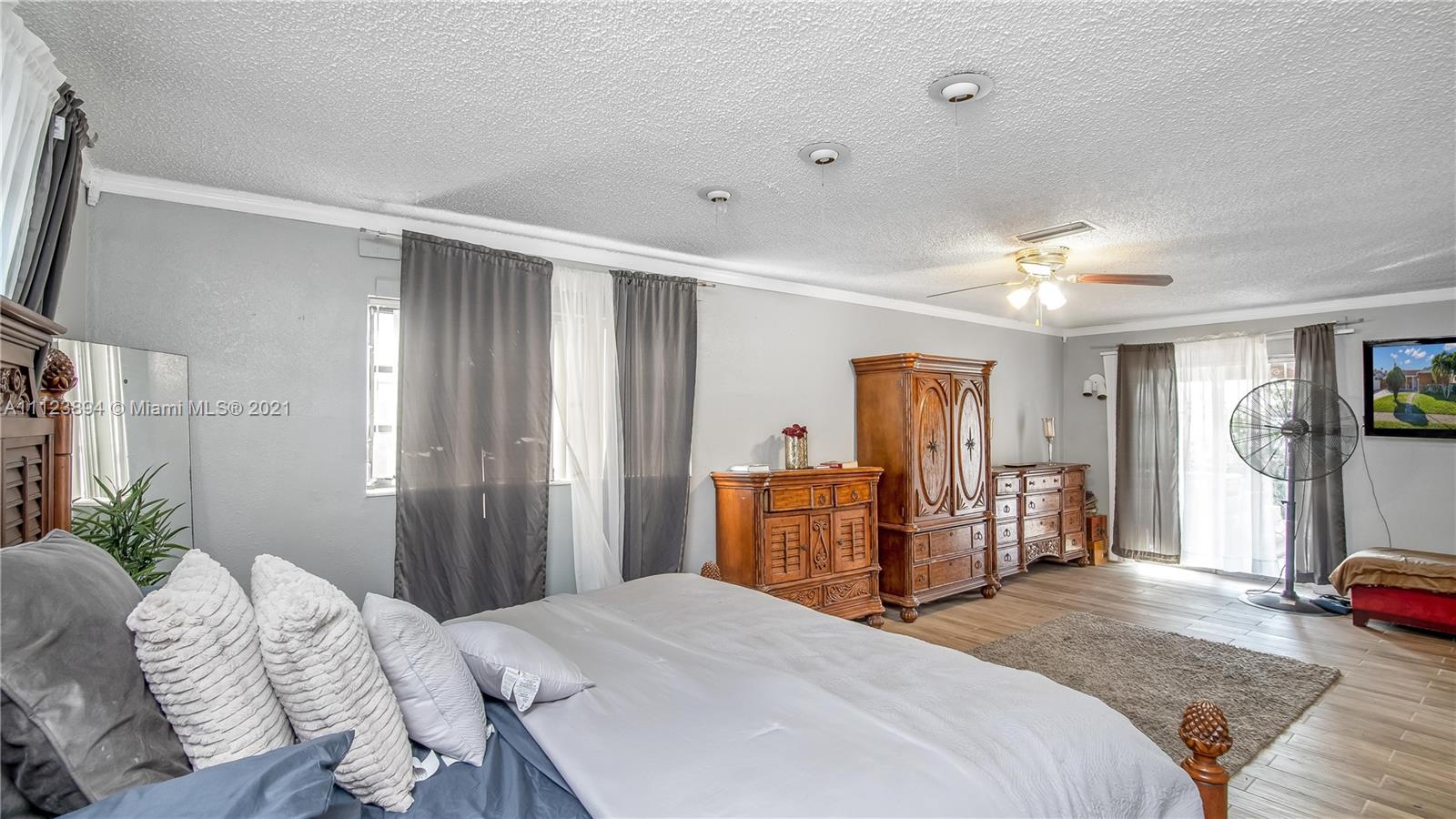 20020 Southwest 112th Avenue Miami, FL 33189 - Photo 27 of 39 a bedroom with a bed and dresser with mirror