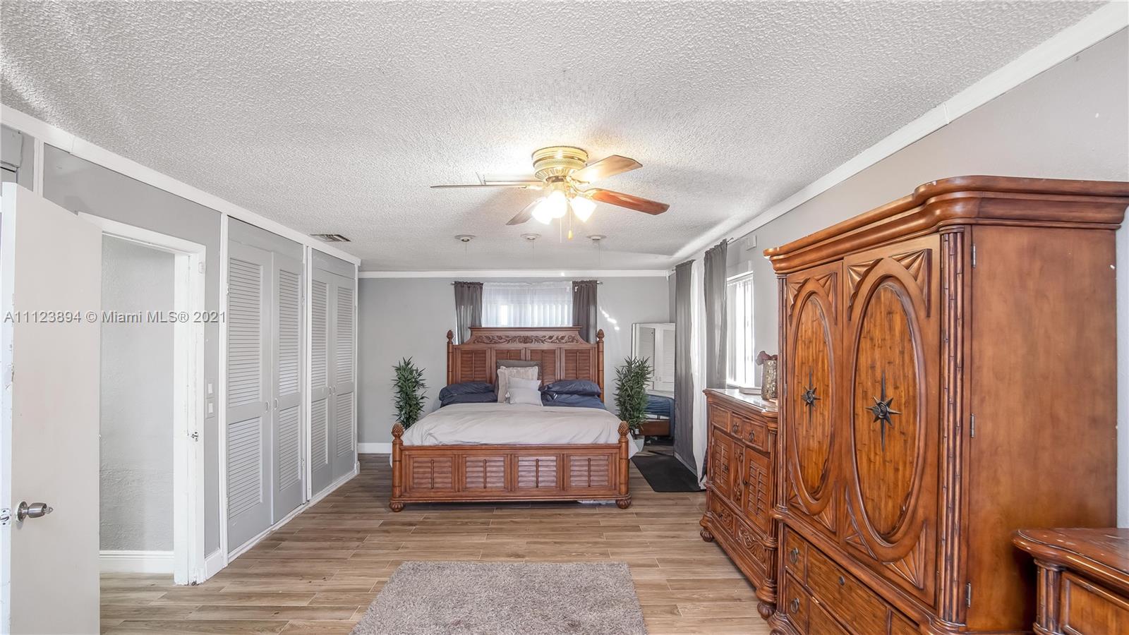 20020 Southwest 112th Avenue Miami, FL 33189 - Photo 28 of 39 a bedroom with a bed and a chandelier