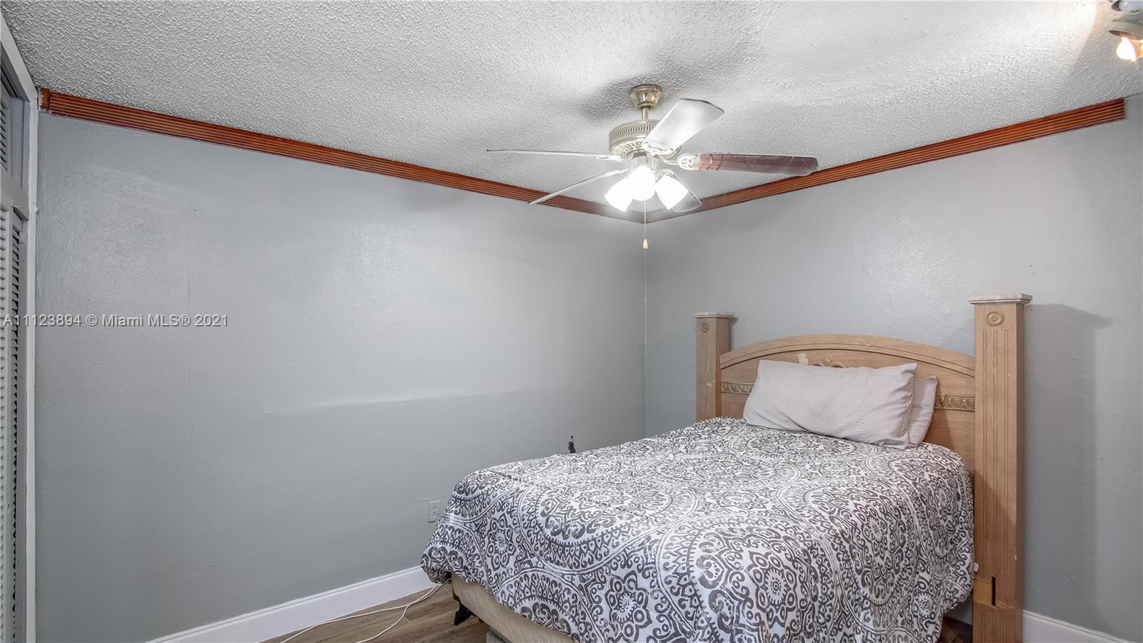 20020 Southwest 112th Avenue Miami, FL 33189 - Photo 31 of 39 a bedroom with a bed and a chandelier