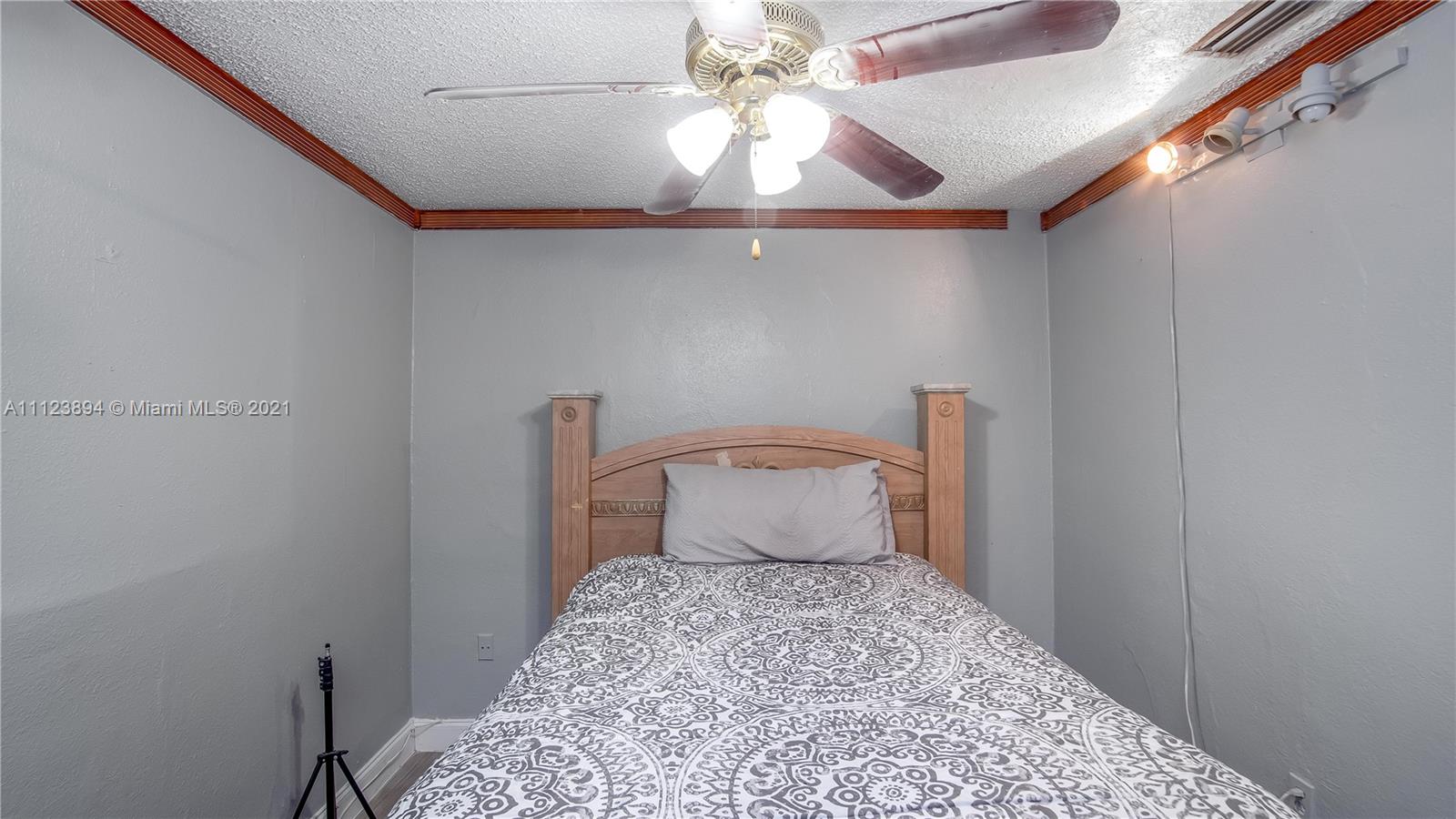 20020 Southwest 112th Avenue Miami, FL 33189 - Photo 32 of 39 a bedroom with a bed and a chandelier