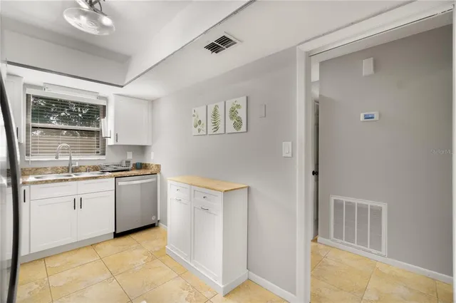 a kitchen with granite countertop a sink and cabinets