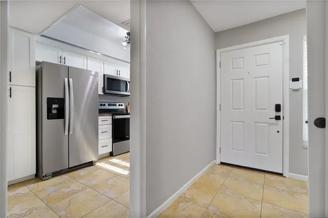 a view of a kitchen with an empty space and a refrigerator