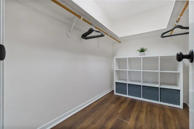 a view of an empty room with wooden floor and closet