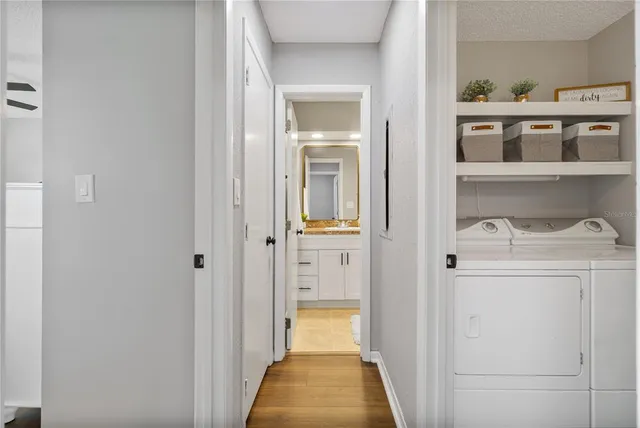 a view of a hallway with white cabinet a wooden floor and a front door
