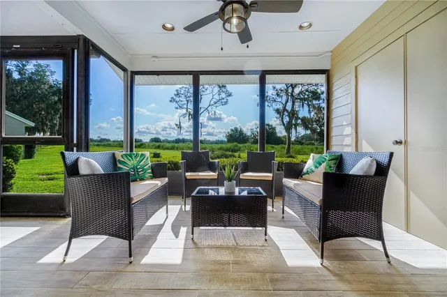 a living room with patio furniture and a large window