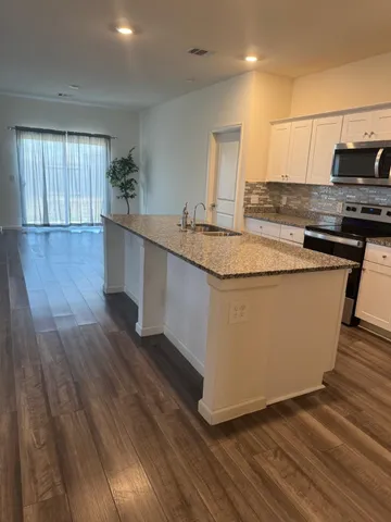 a kitchen with wooden floors and wide window
