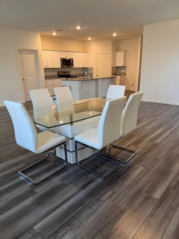 a living room kitchen with furniture and a wooden floor