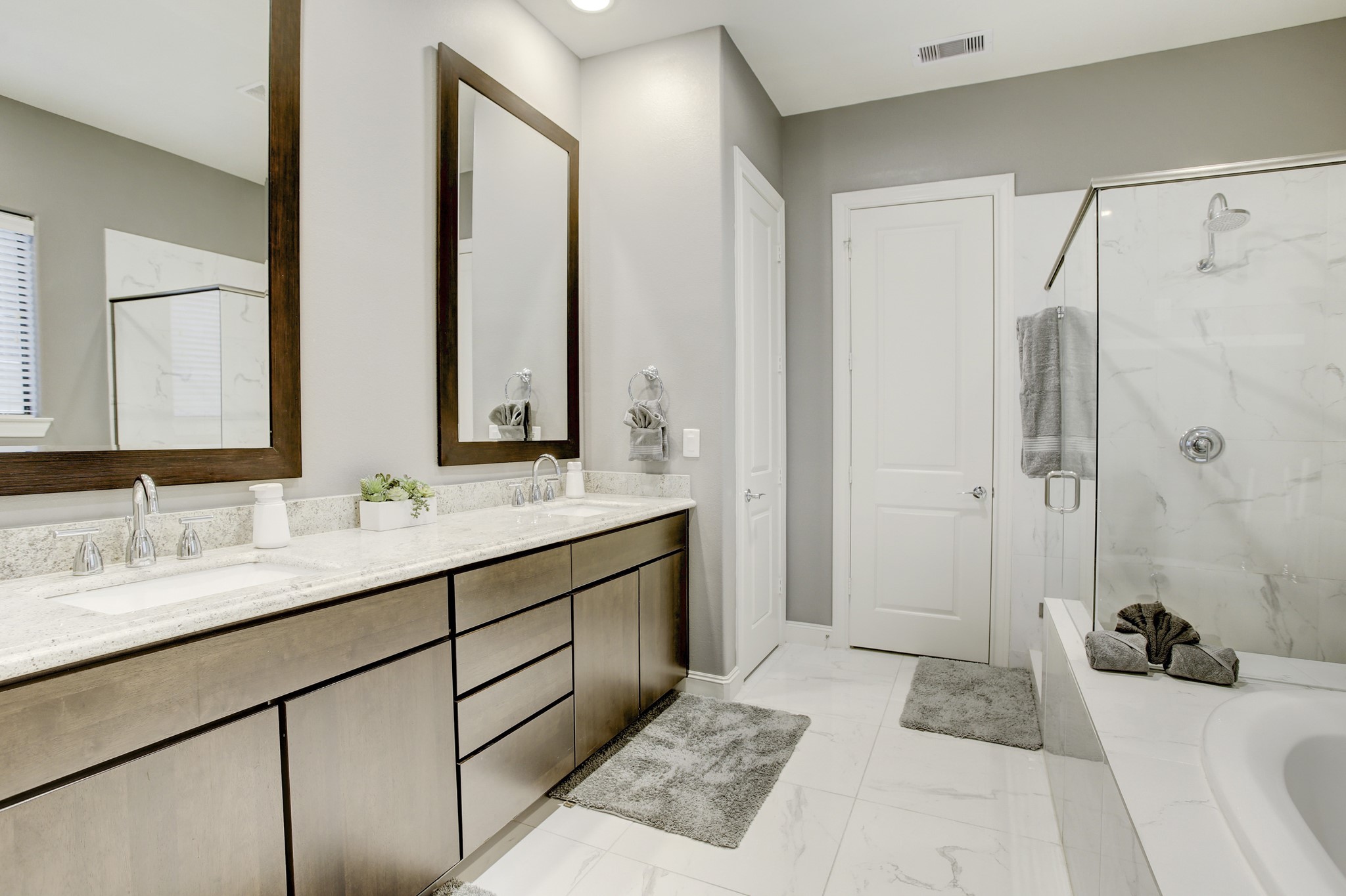 5506 Darling Street Houston, TX 77007 - Photo 12 of 23 The Primary Ensuite Bath has a wide vanity with double sinks & a granite countertop, tile flooring, a deep soaking tub, a separate walk-in shower with tile surround, linen closet and 2 walk-in closets.