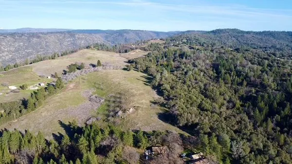 an aerial view of mountain with yard