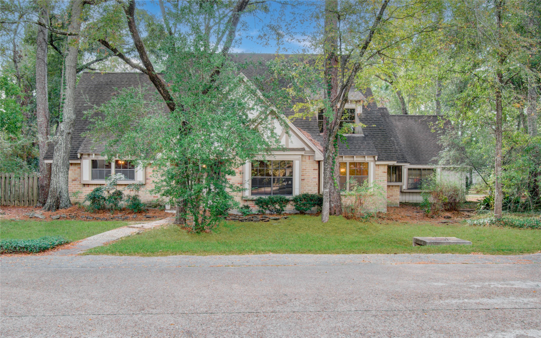 a view of a house with a yard and large trees