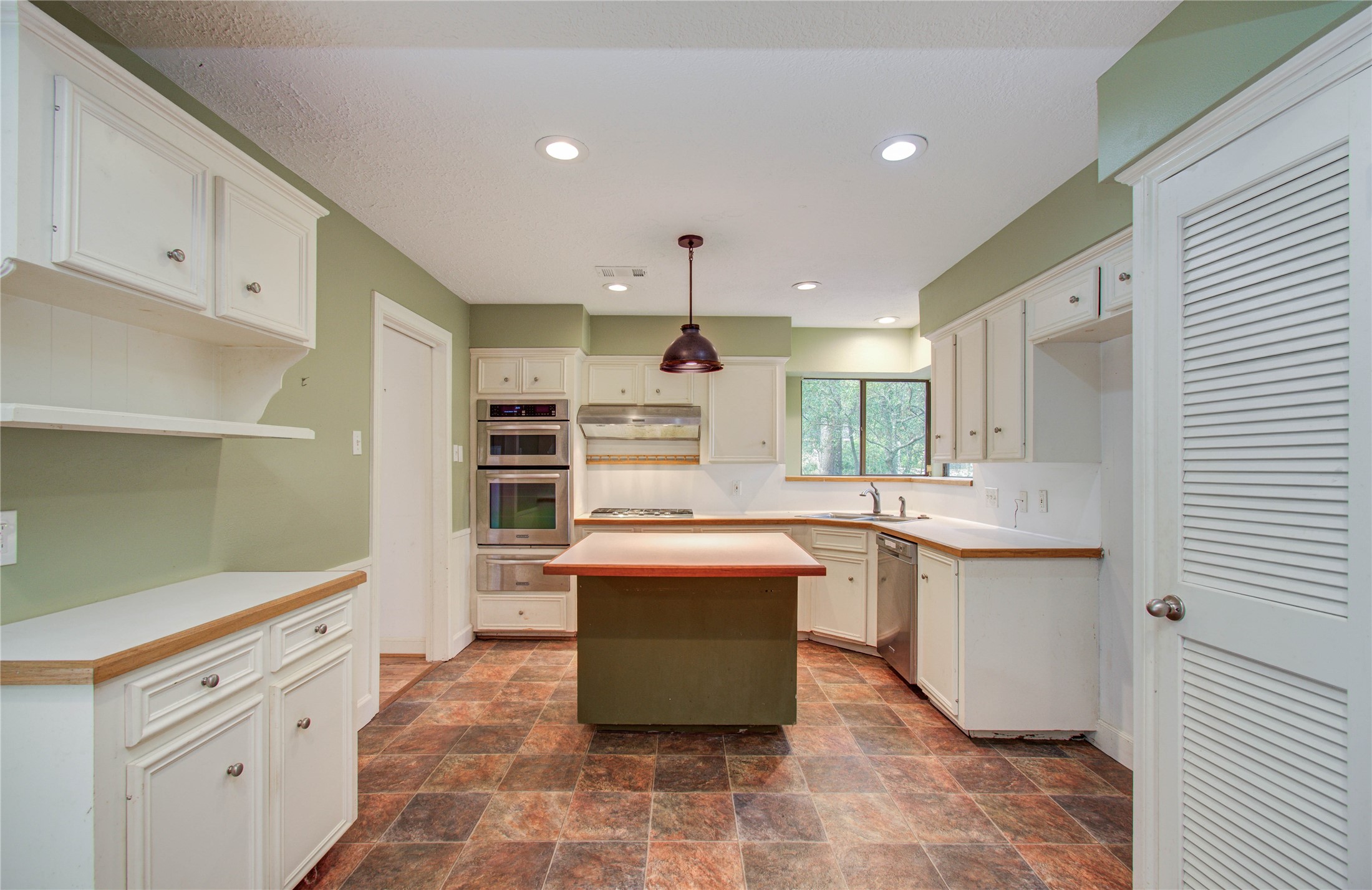 10715 East Timberwagon Circle Spring, TX 77380 - Photo 19 of 50 a kitchen with kitchen island a sink stainless steel appliances and cabinets