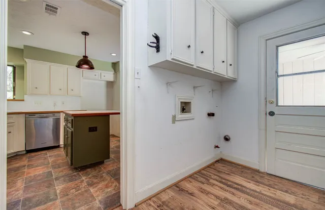 a kitchen with cabinets and wooden floor