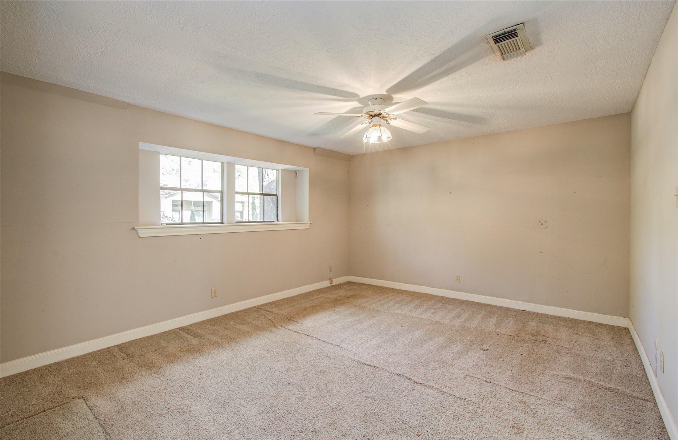 10715 East Timberwagon Circle Spring, TX 77380 - Photo 31 of 50 an empty room with windows and fan