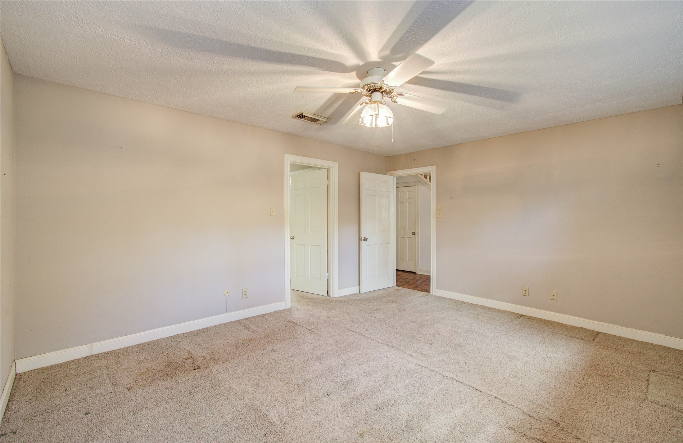 10715 East Timberwagon Circle Spring, TX 77380 - Photo 32 of 50 an empty room with a chandelier fan and windows