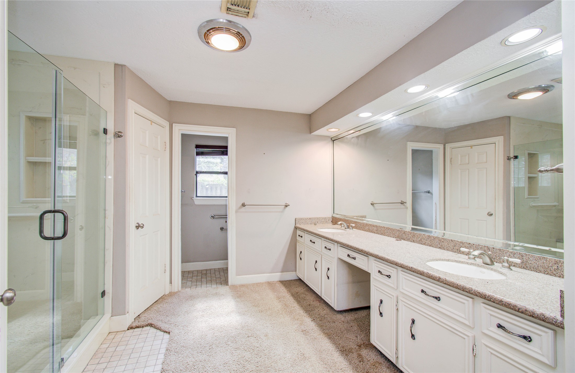 10715 East Timberwagon Circle Spring, TX 77380 - Photo 34 of 50 a spacious bathroom with a double vanity sink a large mirror and shower