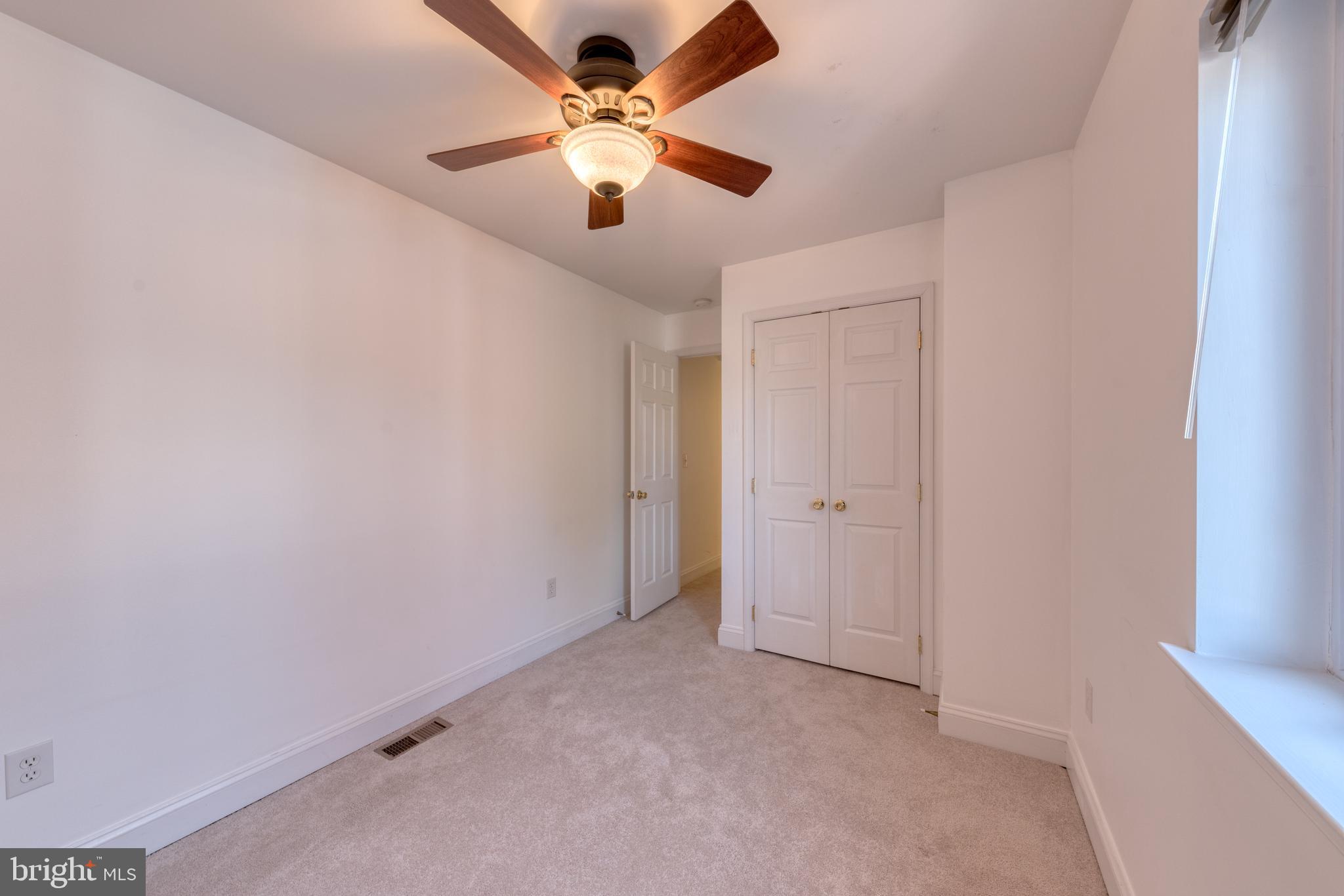 1818 Bank Street Baltimore, MD 21231 - Photo 17 of 20 an empty room with a chandelier fan and windows