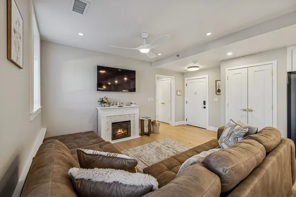 a living room with furniture a fireplace and a flat screen tv