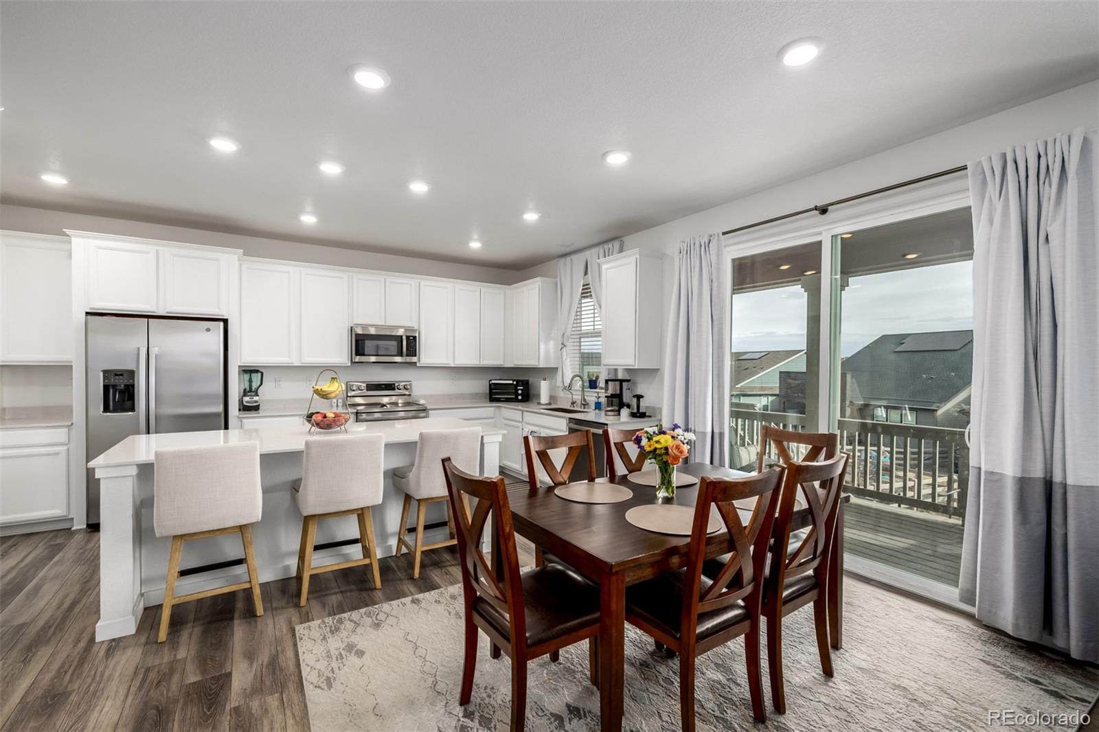 8184 Mt Lincoln Road Littleton, CO 80125 - Photo 13 of 46 a view of a dining room and livingroom with furniture a rug a kitchen and a chandelier