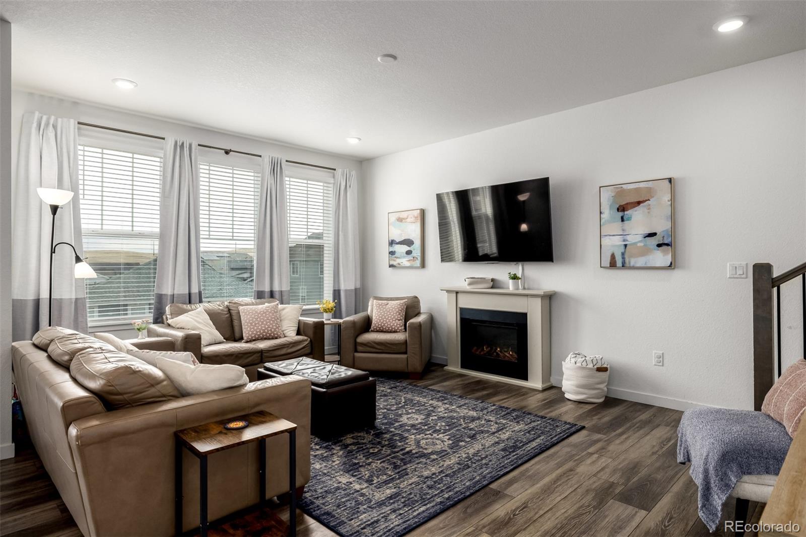8184 Mt Lincoln Road Littleton, CO 80125 - Photo 15 of 46 a living room with furniture a flat screen tv and a fireplace