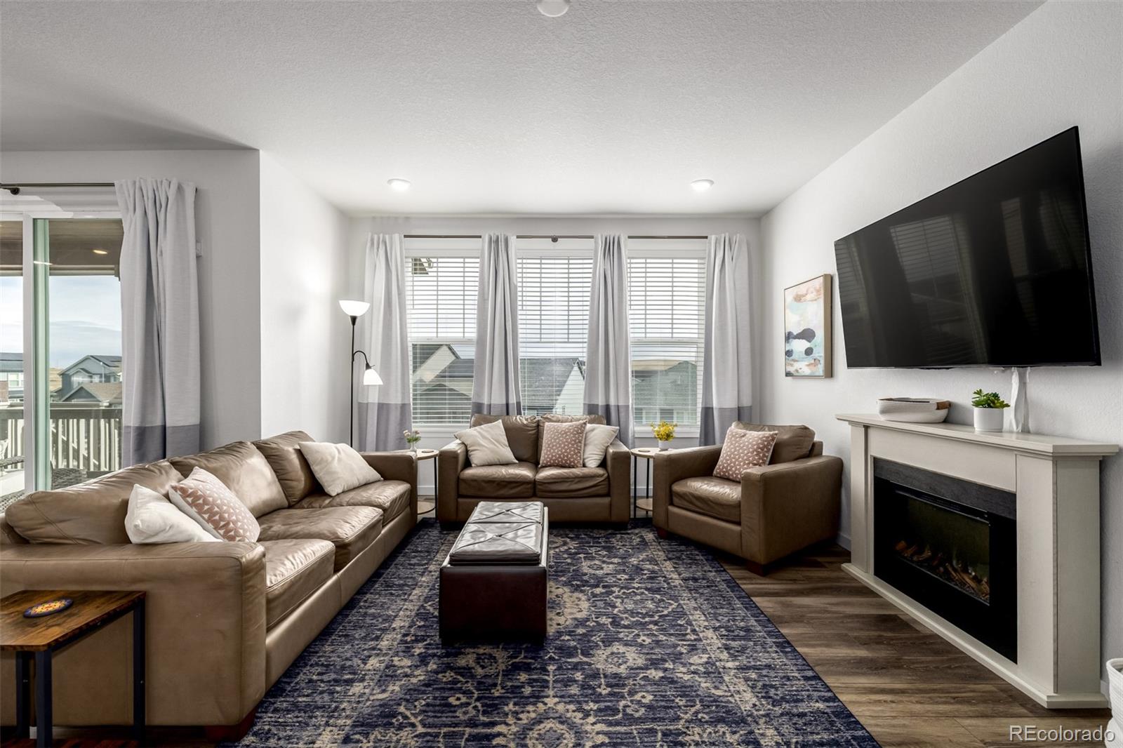 8184 Mt Lincoln Road Littleton, CO 80125 - Photo 17 of 46 a living room with furniture a flat screen tv and a fireplace
