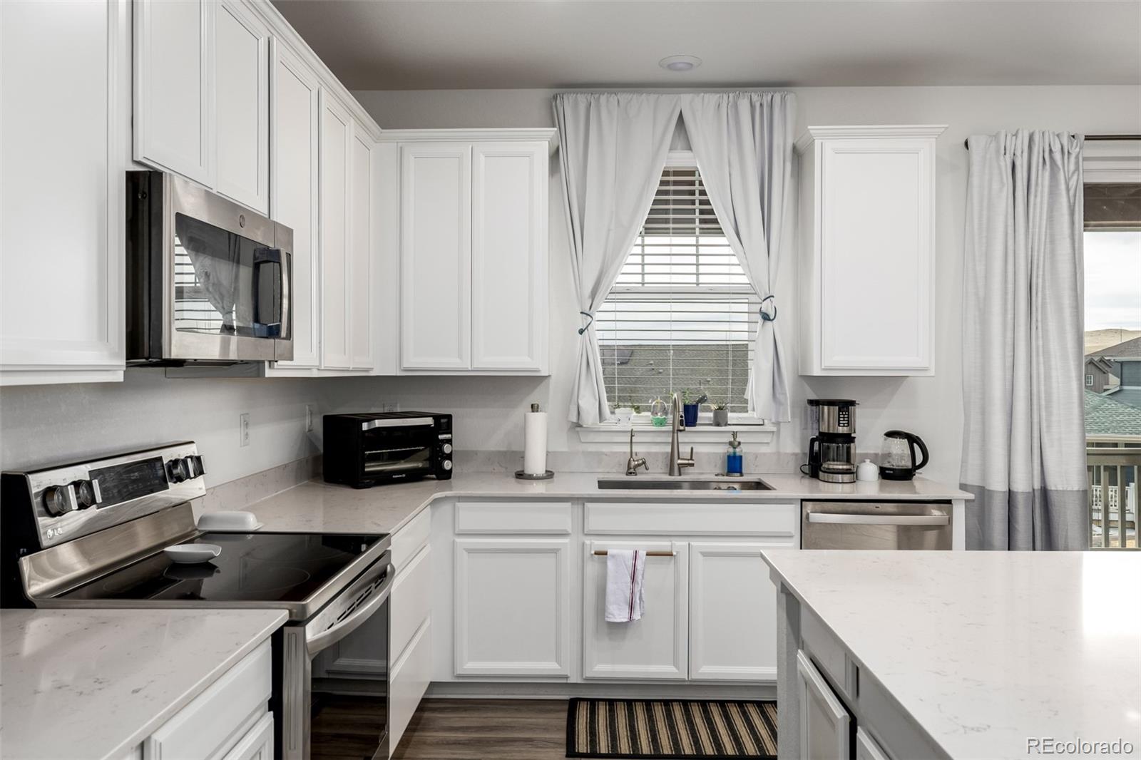 8184 Mt Lincoln Road Littleton, CO 80125 - Photo 8 of 46 a kitchen with granite countertop a sink a stove and cabinets