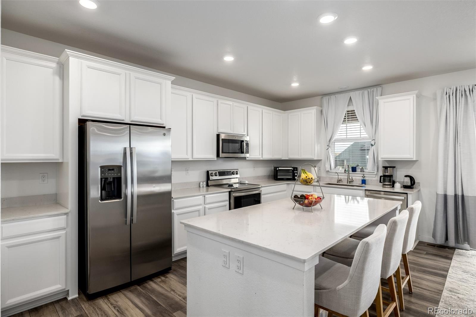 8184 Mt Lincoln Road Littleton, CO 80125 - Photo 9 of 46 a kitchen with a refrigerator a stove a sink and a microwave