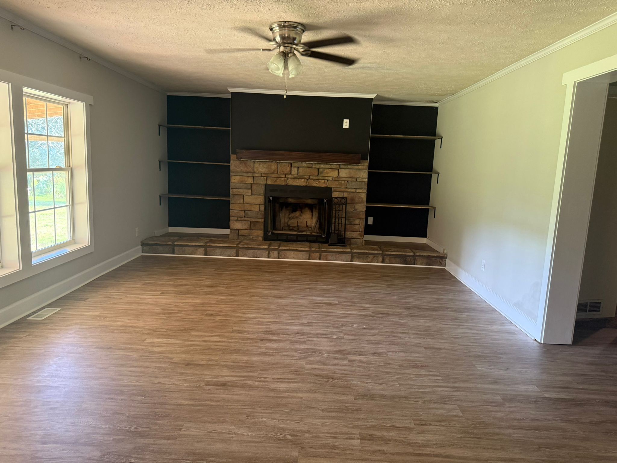 4920 Youngville Road Springfield, TN 37172 - Photo 22 of 54 an empty room with wooden floor a fireplace and windows