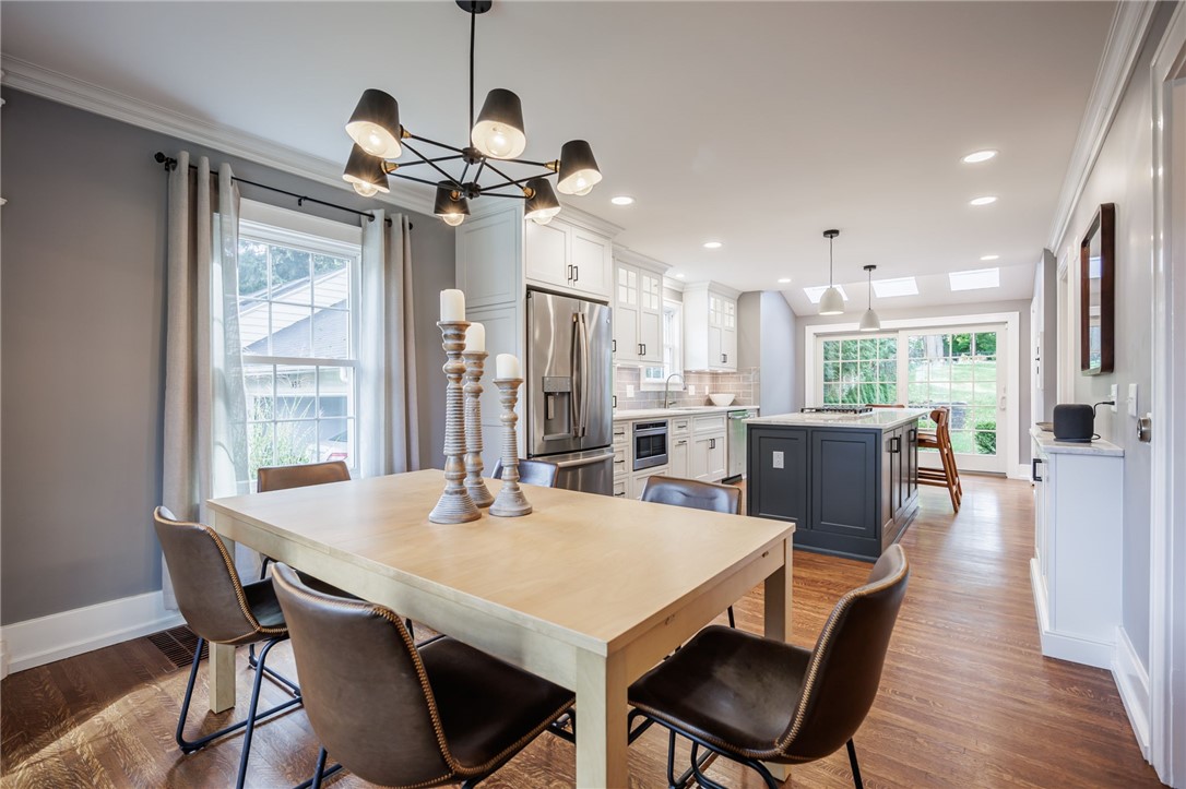 387 Kilbourn Road Rochester, NY 14618 - Photo 42 of 42 An open floorplan seamlessly connects the dining space to a modern kitchen with hardwood flooring.