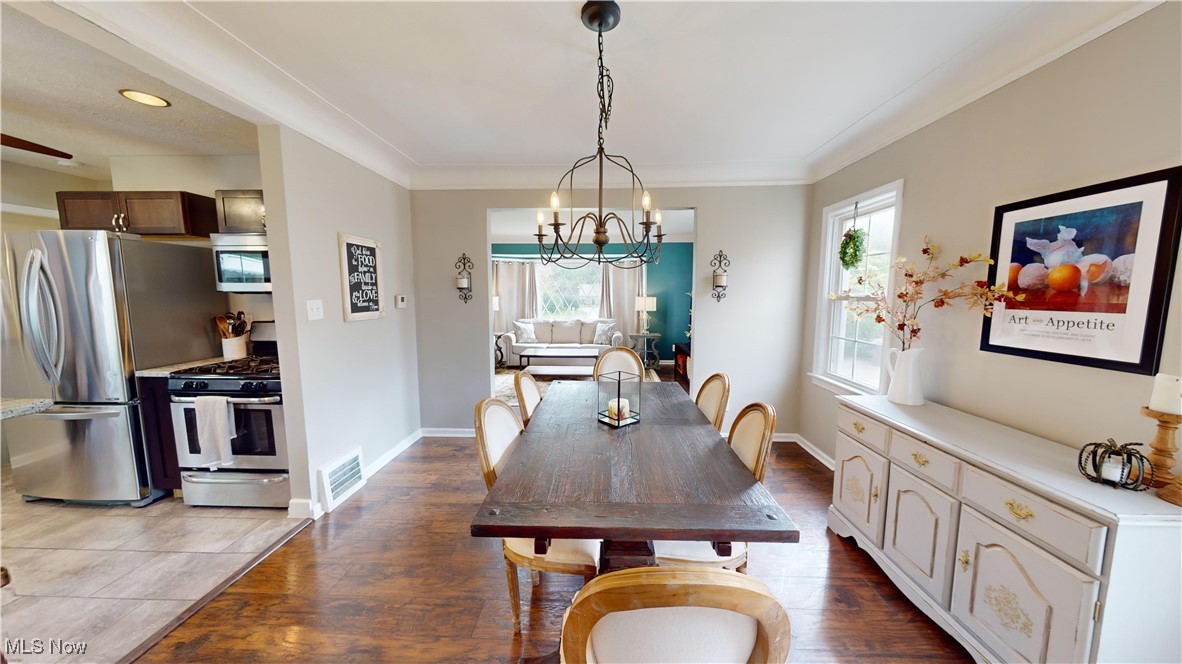 2412 Charney Road Cleveland, OH 44118 - Photo 10 of 48 Dining space featuring a notable chandelier, dark hardwood / wood-style floors, and ornamental molding