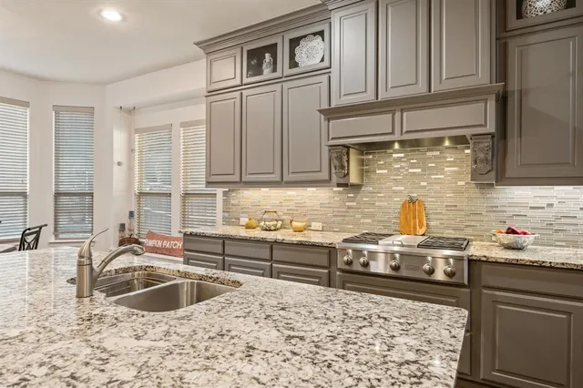 a kitchen with stainless steel appliances granite countertop a sink stove and cabinets
