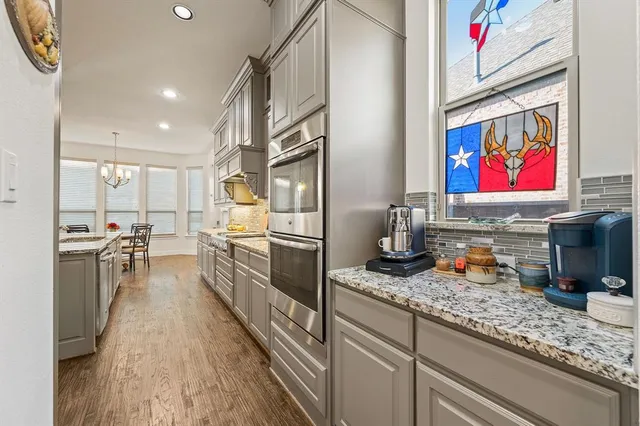 a kitchen with kitchen island a stove a sink a oven and a refrigerator